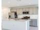Modern kitchen featuring stainless steel appliances, neutral cabinets, and a large island with sink at 12466 Gust Ct, Hudson, FL 34669