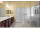 Modern bathroom featuring a double vanity, a walk-in shower, and tile flooring at 13312 Tiger Lilly Ln, Tampa, FL 33625