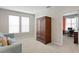 Bedroom with large armoire and views into connected office space with desk at 13312 Tiger Lilly Ln, Tampa, FL 33625