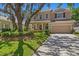 Charming two-story home featuring a well-manicured lawn, mature landscaping, and a welcoming two-car garage at 13312 Tiger Lilly Ln, Tampa, FL 33625