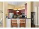 Well-equipped kitchen with bar seating, stainless steel appliances, and dark wood cabinets at 13312 Tiger Lilly Ln, Tampa, FL 33625