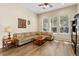 Bright living room featuring hardwood floors, a comfortable sofa, and large windows at 13312 Tiger Lilly Ln, Tampa, FL 33625