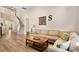 Inviting living room featuring hardwood floors, a plush sofa, and an adjacent staircase at 13312 Tiger Lilly Ln, Tampa, FL 33625