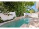 Inviting pool area with a waterfall feature, landscaping, and lounge chairs under a turquoise umbrella at 13312 Tiger Lilly Ln, Tampa, FL 33625