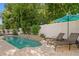 Inviting pool area with lush landscaping, a rock waterfall feature, and a lounging area at 13312 Tiger Lilly Ln, Tampa, FL 33625