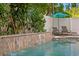 Inviting pool featuring a waterfall, lush landscaping, and comfortable lounge chairs at 13312 Tiger Lilly Ln, Tampa, FL 33625