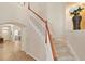 Carpeted staircase features wood banister and white risers, with entry hallway and room visible at 13312 Tiger Lilly Ln, Tampa, FL 33625