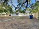 View of the exterior and backyard of the home with mature trees at 1361 Overlea St, Clearwater, FL 33755