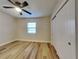 Bedroom featuring wood-look floors, closet with sliding doors, and a ceiling fan at 1361 Overlea St, Clearwater, FL 33755