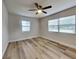 This bedroom features neutral walls, wood-look flooring, a ceiling fan and two windows at 1361 Overlea St, Clearwater, FL 33755