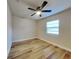 This bedroom features neutral walls, wood-look flooring, a ceiling fan and a large window at 1361 Overlea St, Clearwater, FL 33755