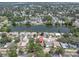 Aerial view of home near a tranquil lake, surrounded by lush greenery and neighborhood streets at 1428 Chesterfield Dr, Dunedin, FL 34698