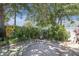 Backyard patio with stone firepit surrounded by a lush, green landscape at 1428 Chesterfield Dr, Dunedin, FL 34698
