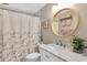A bathroom featuring a white vanity, marble countertops, and a shower curtain at 1428 Chesterfield Dr, Dunedin, FL 34698