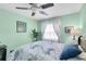 Cozy bedroom with mint walls, ceiling fan, and soft natural light from the large window at 1428 Chesterfield Dr, Dunedin, FL 34698