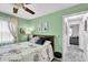 Bedroom with light-green walls, carpet flooring, a window with curtains, and a door leading to the hall at 1428 Chesterfield Dr, Dunedin, FL 34698