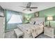 Sunlit bedroom featuring stylish decor, a floral bedspread, and soft carpeting at 1428 Chesterfield Dr, Dunedin, FL 34698