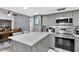 Modern kitchen with gray cabinetry, stainless appliances, and a spacious island at 1428 Chesterfield Dr, Dunedin, FL 34698