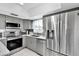 Well-lit kitchen with stainless steel appliances and gray cabinetry at 1428 Chesterfield Dr, Dunedin, FL 34698