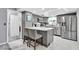 Bright kitchen featuring a center island with seating, gray cabinets, and stainless appliances at 1428 Chesterfield Dr, Dunedin, FL 34698