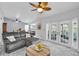 Comfortable living room with sliding doors, a ceiling fan, and a gray couch at 1428 Chesterfield Dr, Dunedin, FL 34698
