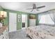 Bright main bedroom featuring light green walls, a TV, and an ensuite bathroom at 1428 Chesterfield Dr, Dunedin, FL 34698