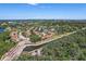 An aerial view of a residential area with a lake and lush green trees at 14926 Feather Cove Rd, Clearwater, FL 33762