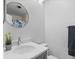 Bright bathroom with gray vanity, round mirror, and shower with blue floral shower curtain at 14926 Feather Cove Rd, Clearwater, FL 33762