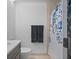 Neutral bathroom featuring a vanity, commode, towel bar, and shower with floral shower curtain at 14926 Feather Cove Rd, Clearwater, FL 33762