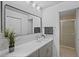 Bright bathroom with a modern vanity, a large mirror, and a glass-enclosed shower at 14926 Feather Cove Rd, Clearwater, FL 33762