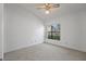 Clean bedroom with neutral carpet, a ceiling fan, and a window view to the neighborhood at 14926 Feather Cove Rd, Clearwater, FL 33762