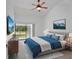 Bright bedroom with a ceiling fan, an exterior door and a scenic painting above the bed at 14926 Feather Cove Rd, Clearwater, FL 33762