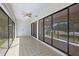 Open sunroom with tile flooring, ceiling fan, and sliding glass doors to the backyard at 14926 Feather Cove Rd, Clearwater, FL 33762