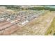 Drone shot displaying an up-and-coming neighborhood with some homes still under construction amid open plots at 15055 Zircon Red Dr, Wimauma, FL 33598