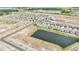New homes from an aerial view showcase completed and ongoing development near a tranquil pond at 15055 Zircon Red Dr, Wimauma, FL 33598