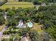 Stunning aerial view of estate home, lush green surroundings, and sparkling pool at 1603 Cottagewood Dr, Brandon, FL 33510