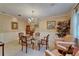 Elegant dining room with a glass table, floral chairs, chandelier, and wainscoting is perfect for gatherings at 1603 Cottagewood Dr, Brandon, FL 33510
