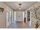 Inviting entryway with brick flooring, floral accents, and a chandelier that creates a warm and welcoming ambiance at 1603 Cottagewood Dr, Brandon, FL 33510