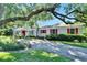 Charming single story home with white brick, red shutters, and mature landscaping at 1603 Cottagewood Dr, Brandon, FL 33510