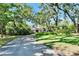 Long driveway leads to a charming home surrounded by mature trees and lush lawn at 1603 Cottagewood Dr, Brandon, FL 33510