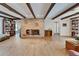 Spacious living room with exposed beams, brick fireplace, and hardwood floors offers classic charm at 1603 Cottagewood Dr, Brandon, FL 33510