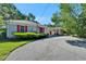 Back exterior view shows a car port and partial brick facade with red shutters at 1603 Cottagewood Dr, Brandon, FL 33510