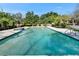 Large swimming pool with concrete deck and mature trees in the background at 1603 Cottagewood Dr, Brandon, FL 33510