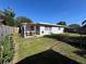 Lush backyard with covered patio, mature landscaping, and privacy fence at 1748 Ragland Ave, Clearwater, FL 33765