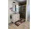 A bathroom featuring a glass shower, white vanity, and tan-colored tile floors at 1748 Ragland Ave, Clearwater, FL 33765