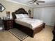 This is a bedroom with a wooden bed frame, matching nightstands, and tan-colored tile floors at 1748 Ragland Ave, Clearwater, FL 33765