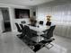 Dining room with a modern white table, black chairs, and large windows with sheer curtains at 1748 Ragland Ave, Clearwater, FL 33765