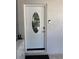 Elegant white front door with an oval glass insert and modern security features at 1748 Ragland Ave, Clearwater, FL 33765