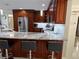 Modern kitchen features stainless steel appliances, wood cabinets, granite countertops, and bar seating at 1748 Ragland Ave, Clearwater, FL 33765