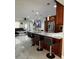 Modern kitchen featuring a granite island with seating, stainless steel appliances, and white marble floors at 1748 Ragland Ave, Clearwater, FL 33765